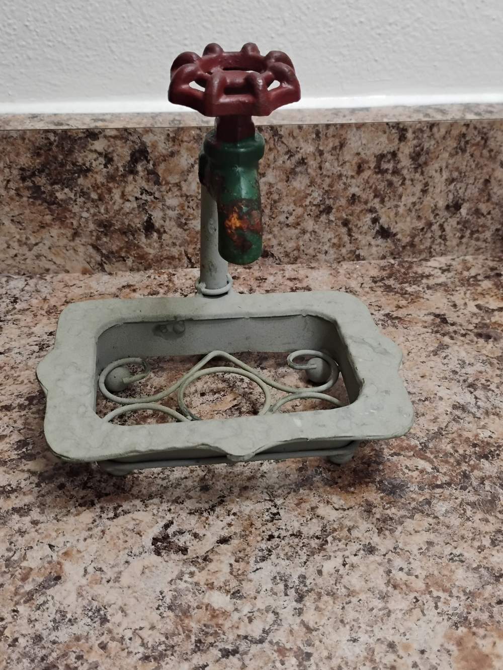 Rustic metal soap dish Vintage with a decorative faucet design and a red handle.